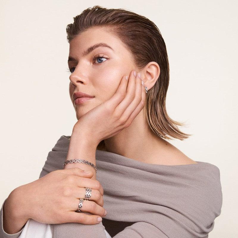 Elegant Daniel Wellington 3-link silver stainless steel bracelet worn on a model's wrist for a sophisticated look.