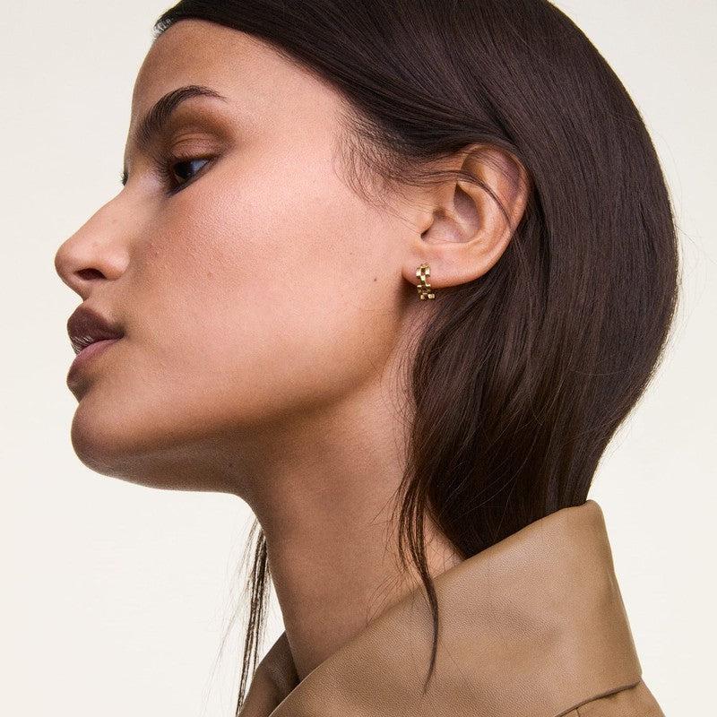 Elegant Daniel Wellington 3-link gold stainless steel hoop earrings, 13.6mm, worn on a model for a refined look.