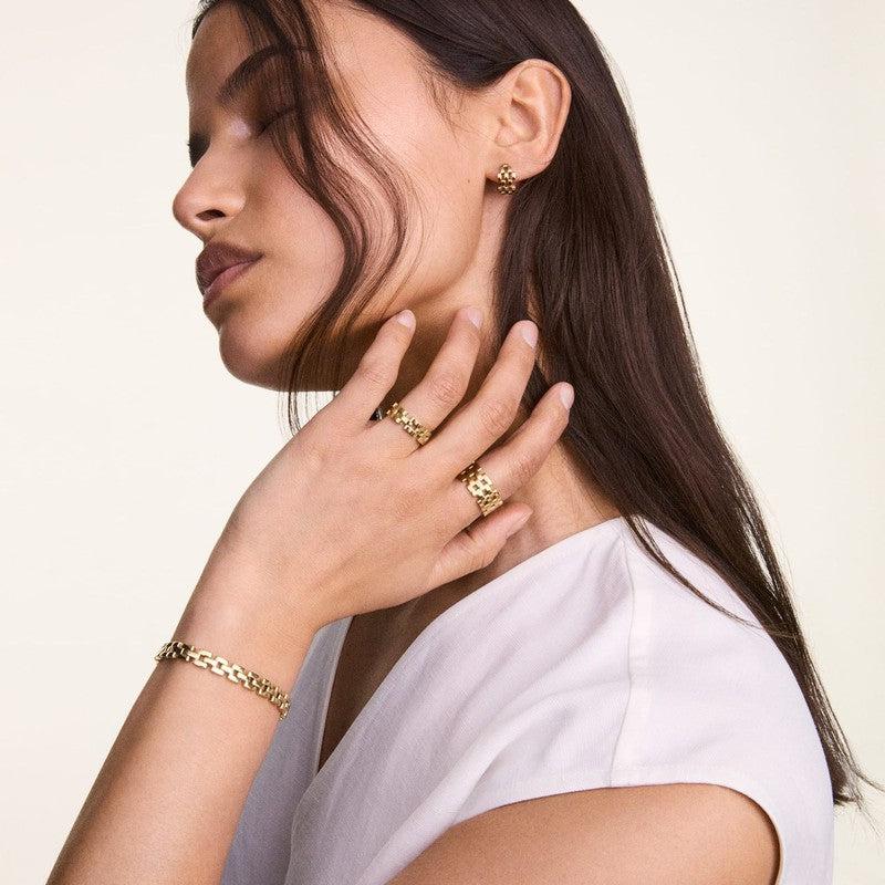 Elegant Daniel Wellington 5-link ring in gold-plated stainless steel worn on a woman's hand for a sophisticated look.