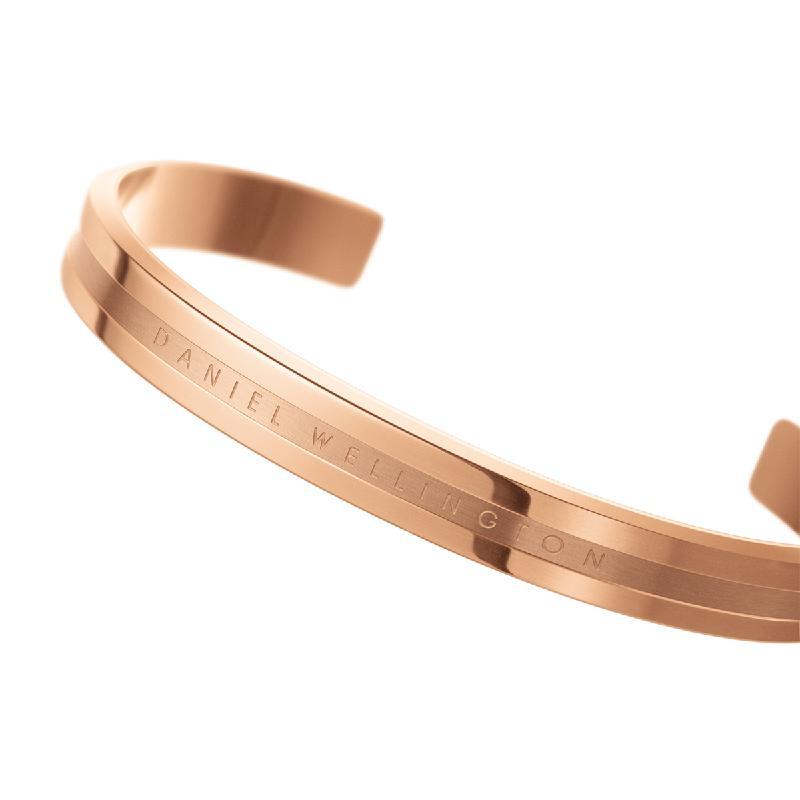 Elegant rose gold-plated stainless steel Daniel Wellington Elan cuff bracelet with engraved logo detailing.