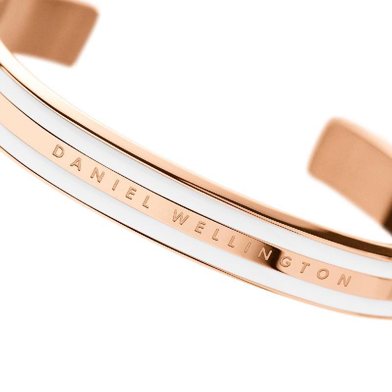 Elegant Daniel Wellington Emalie cuff bracelet in rose gold stainless steel with a sleek white enamel inlay.