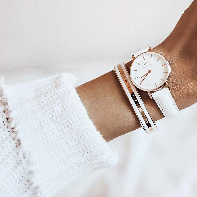 Daniel Wellington Emalie rose gold and white enamel cuff bracelet worn with a matching white leather watch.