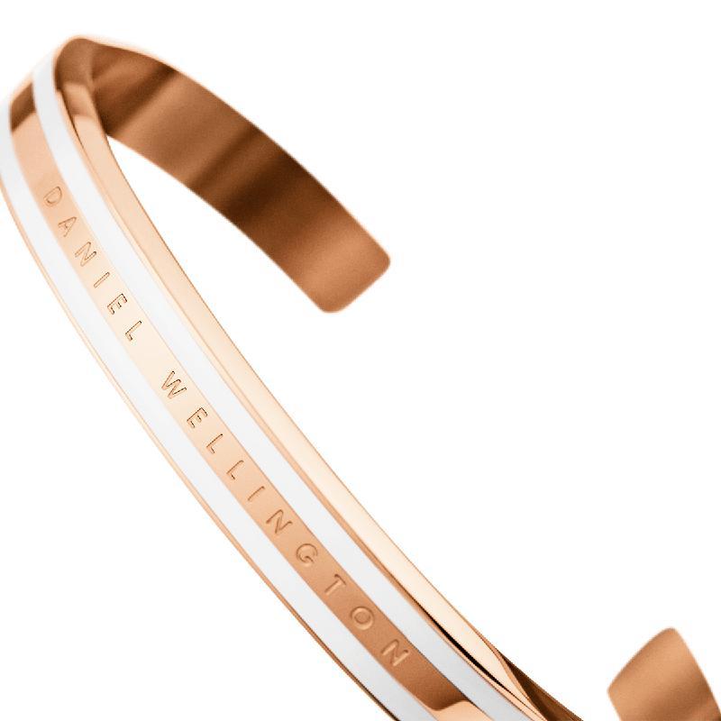Elegant rose gold Daniel Wellington Emalie Slim cuff bracelet featuring a sleek white enamel inlay and engraved logo.