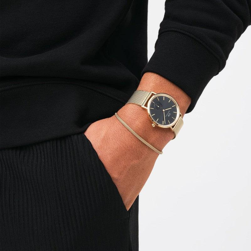 Elegant gold mesh bracelet paired with a matching Daniel Wellington watch for a sophisticated, layered wrist look.