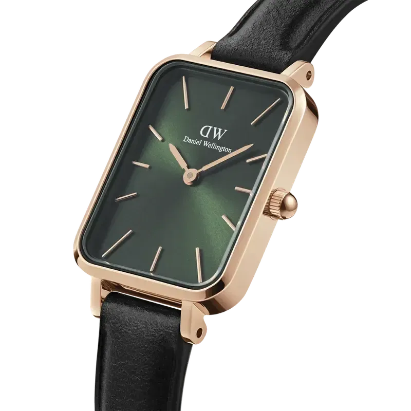 Daniel Wellington Quadro watch with a square rose gold case, emerald green dial, and black leather strap.