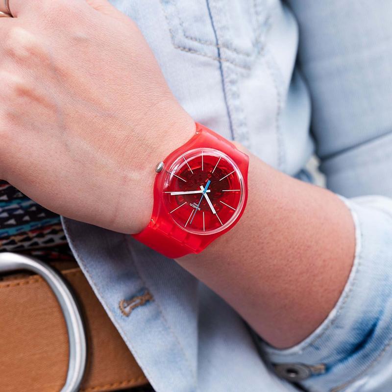 Swatch Bloody Orange watch with a vibrant red translucent dial and frosted silicone strap worn on a wrist.