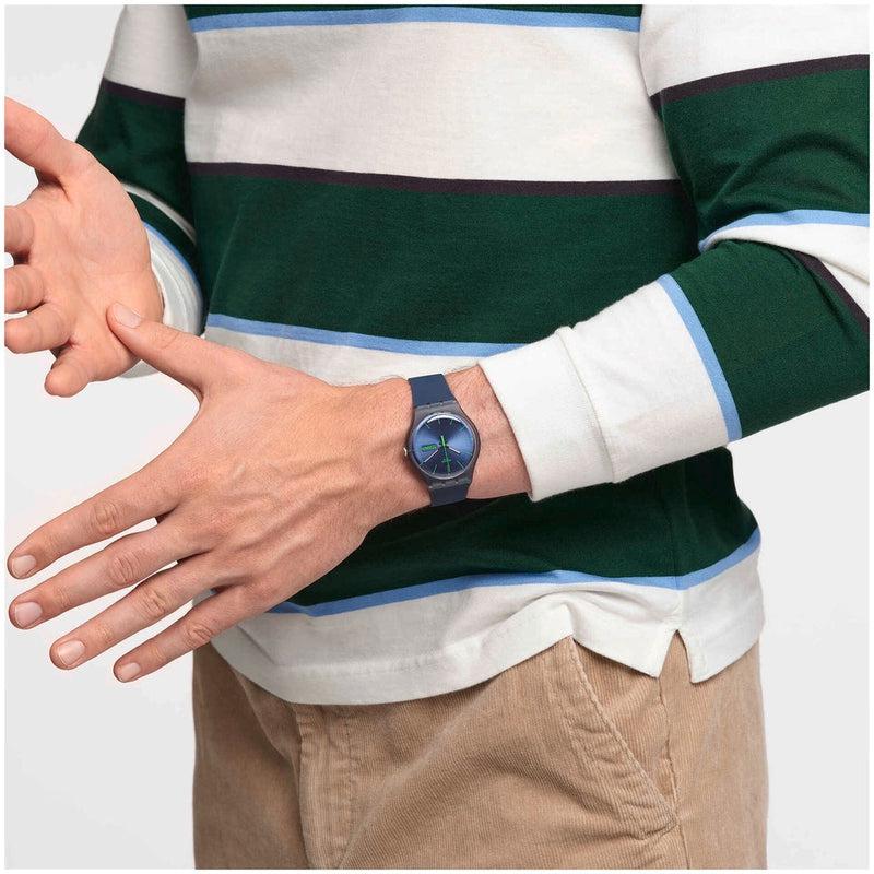 Swatch Blue Rebel watch with a 41mm blue plastic case and comfortable silicone strap, featuring a sleek day-date dial.