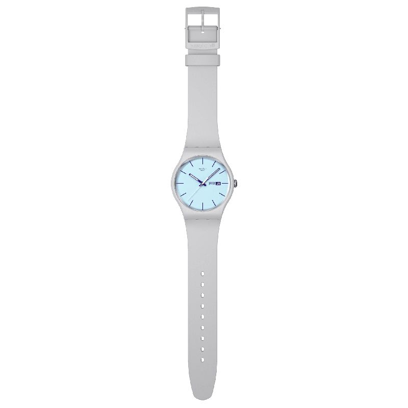 Swatch Blueberry Sky watch with a light blue dial, dark purple indexes, and a matte light gray biosourced silicone strap.