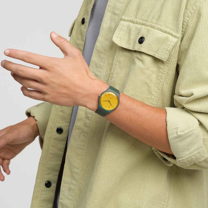 Swatch Gold in the Garden watch with a green biosourced case, silicone strap, and a vibrant, shimmery yellow mirror dial.