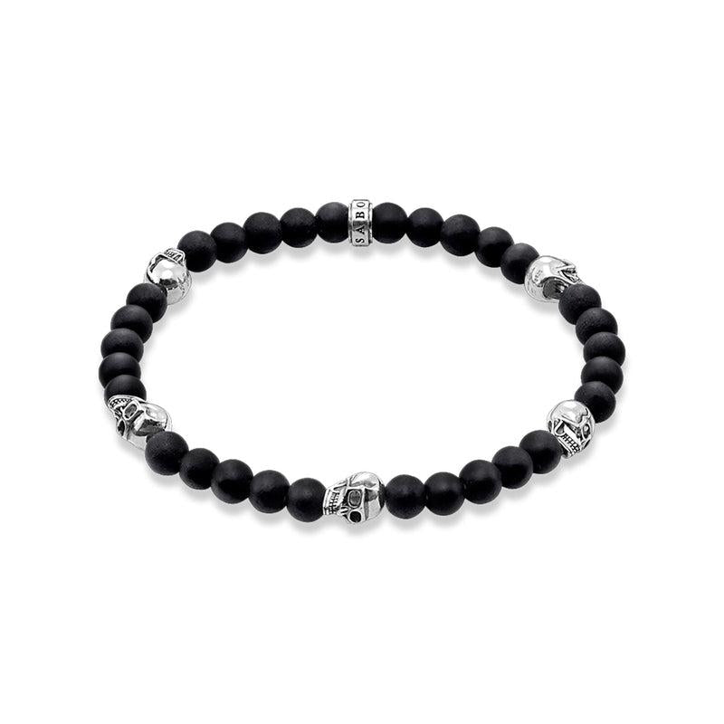 Thomas Sabo beaded bracelet in matte black obsidian with sterling silver skull accents and branded logo bead.