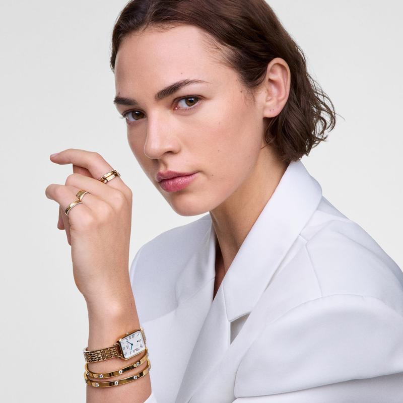 Model wearing a polished gold Daniel Wellington Classic Aura ring featuring sparkling white crystals on her fingers.