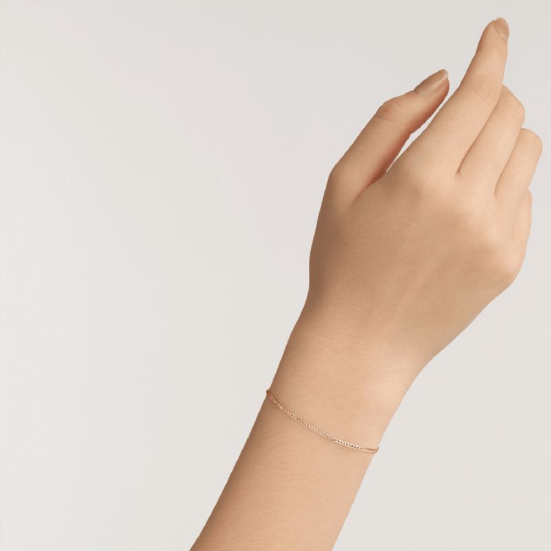 Elegant Daniel Wellington Elan gold-plated stainless steel flat chain bracelet worn on a wrist.