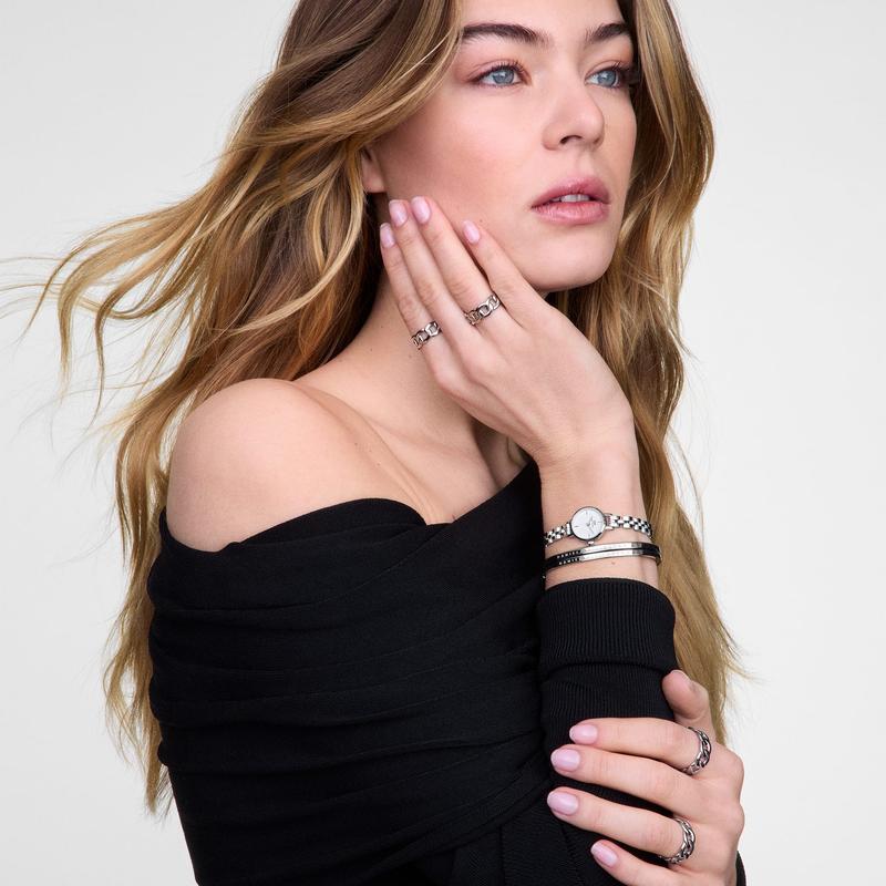 Polished silver Daniel Wellington stainless steel bangle featuring a minimalist design and secure hidden hinge lock.