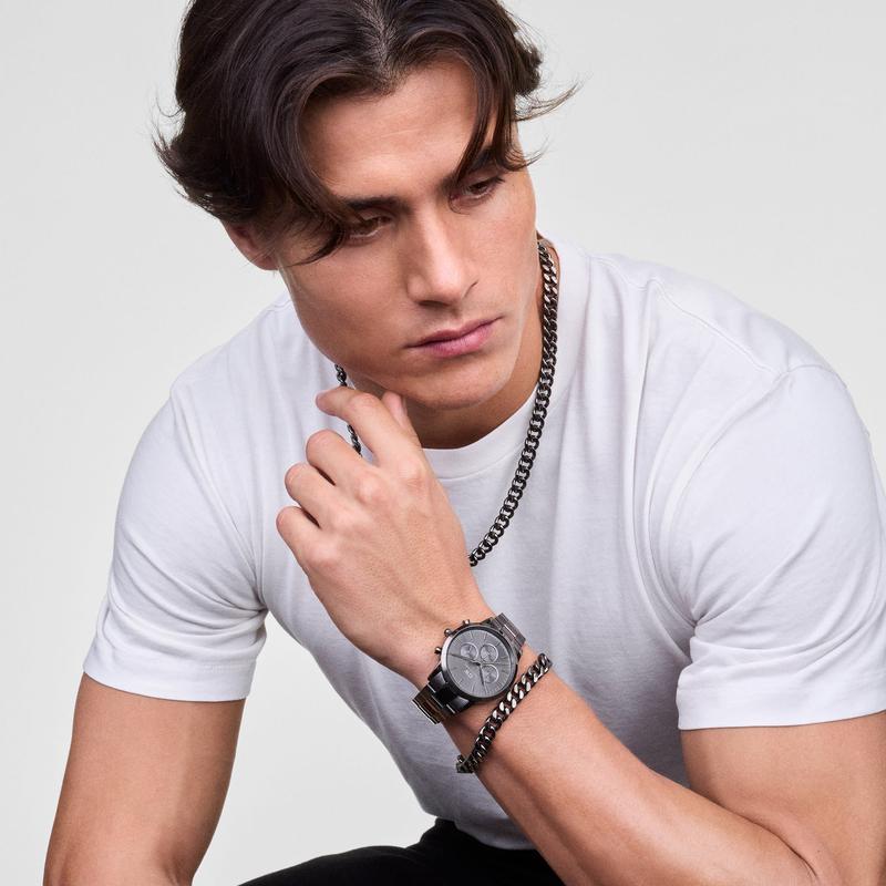 Man wearing a sleek graphite stainless steel Cuban chain bracelet and matching watch for a bold, urban style.
