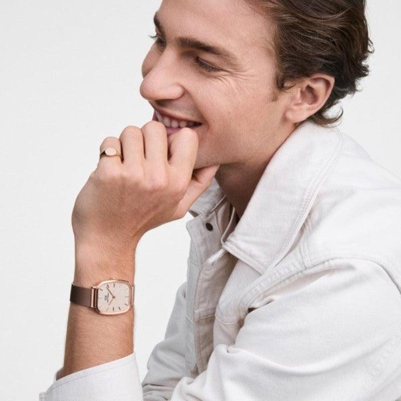 Daniel Wellington Marlon Melrose watch featuring a rose gold mesh strap and elegant linen dial on a man's wrist.