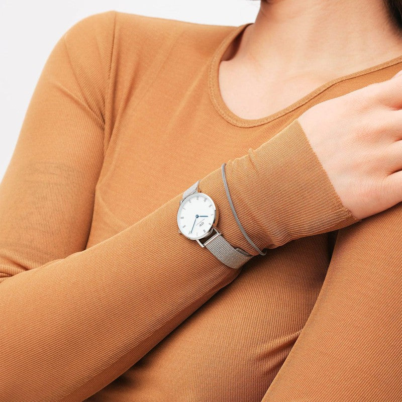 Elegant silver stainless steel mesh bracelet paired with a matching Daniel Wellington watch on a wrist.