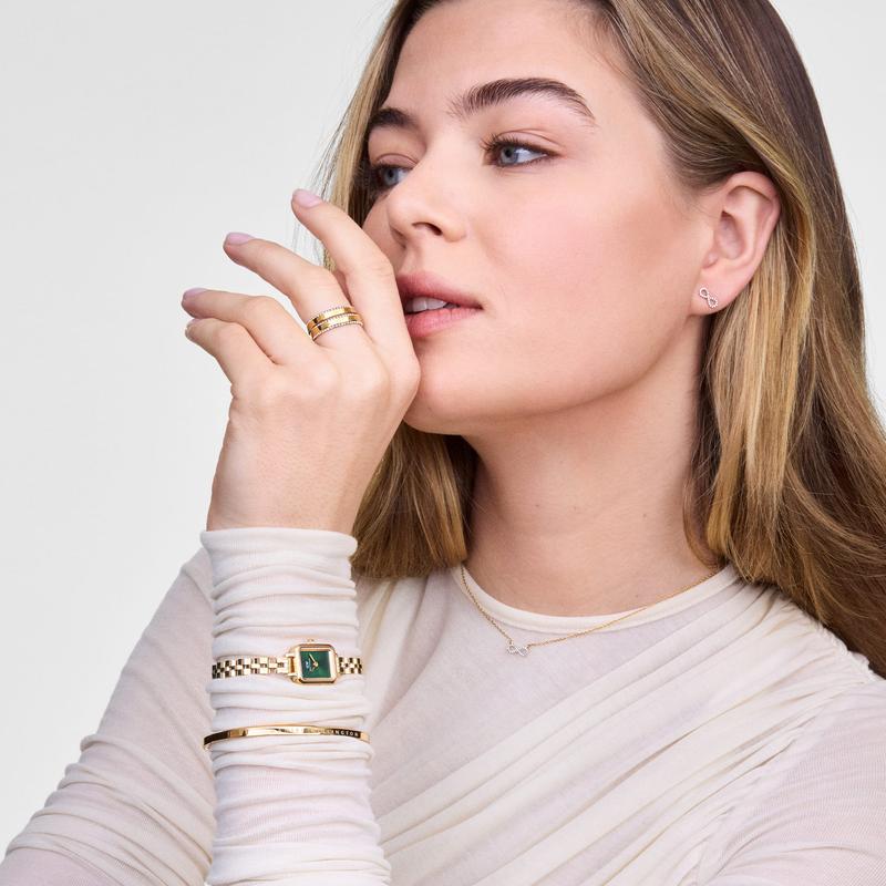 Elegant 14k gold-plated Mirelle infinity earrings featuring sparkling white cubic zirconia stones on a model.