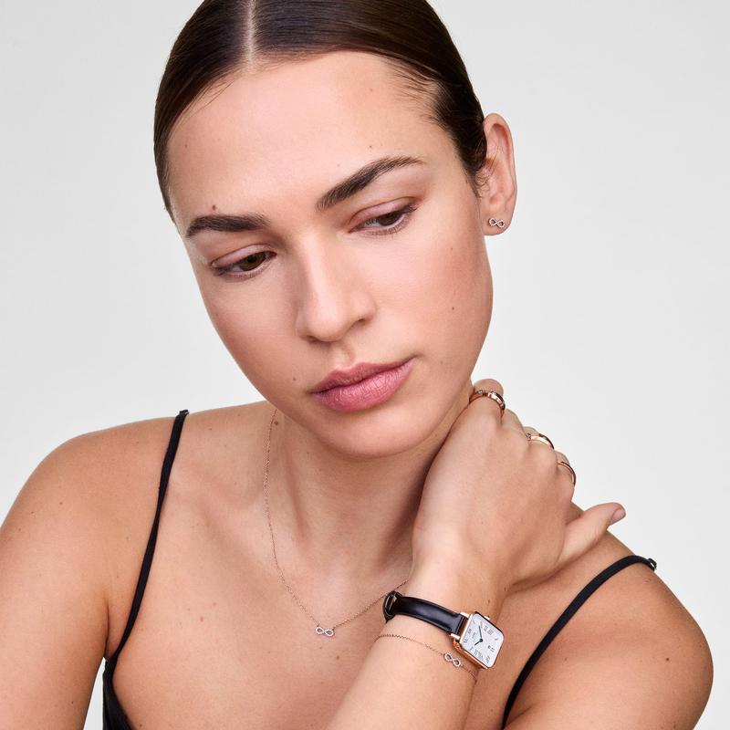 Elegant rose gold infinity earrings with sparkling cubic zirconia, featuring a minimalist design for refined style.