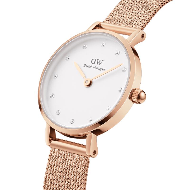Daniel Wellington Petite Lumine 28mm rose gold watch with crystal indexes and a minimalist pressed mesh strap.