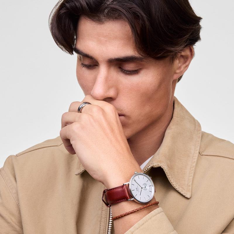 Man wearing a sleek Daniel Wellington braided brown leather bracelet with a polished silver magnetic clasp.